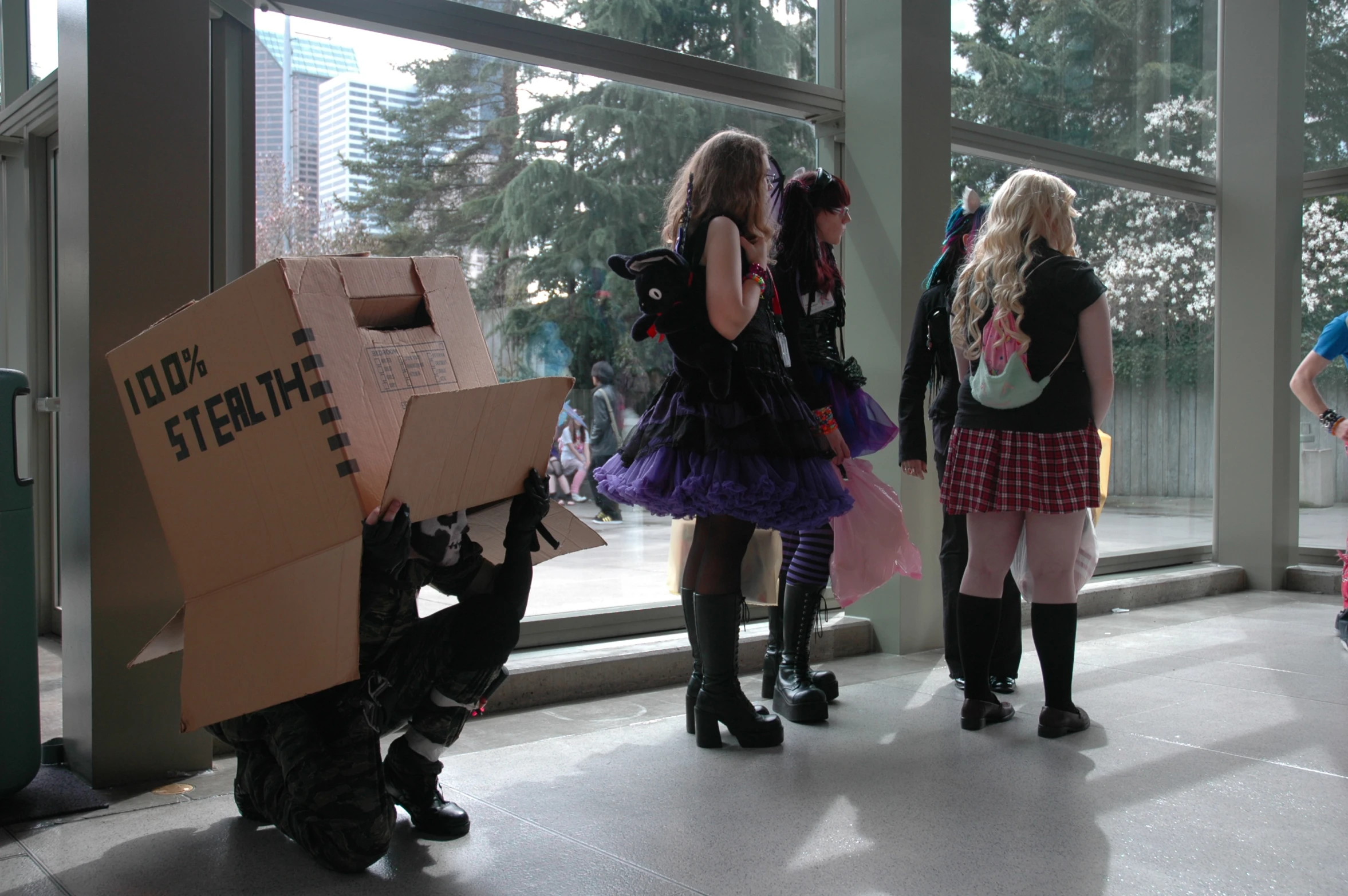 people standing by a window and holding boxes