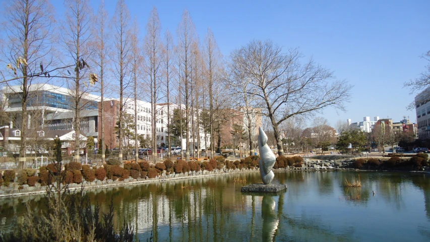 a large pond with a white sculpture of a bird on top