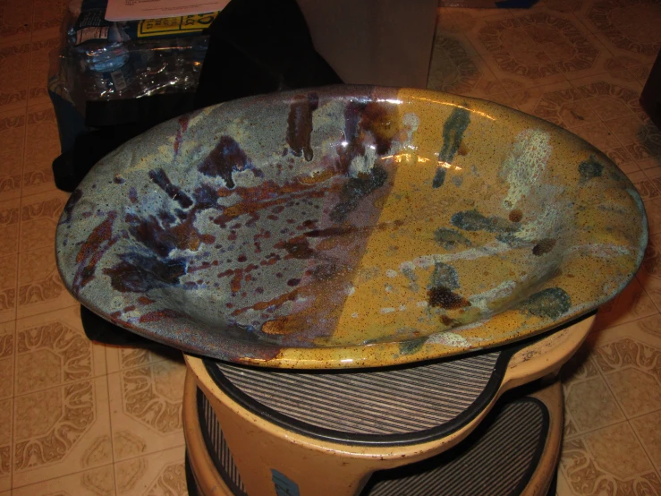 a yellow plate sitting on top of a wooden floor