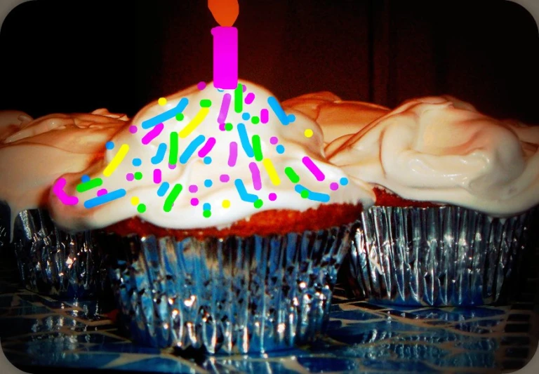 a cupcake with frosting with one candle sticking out of it