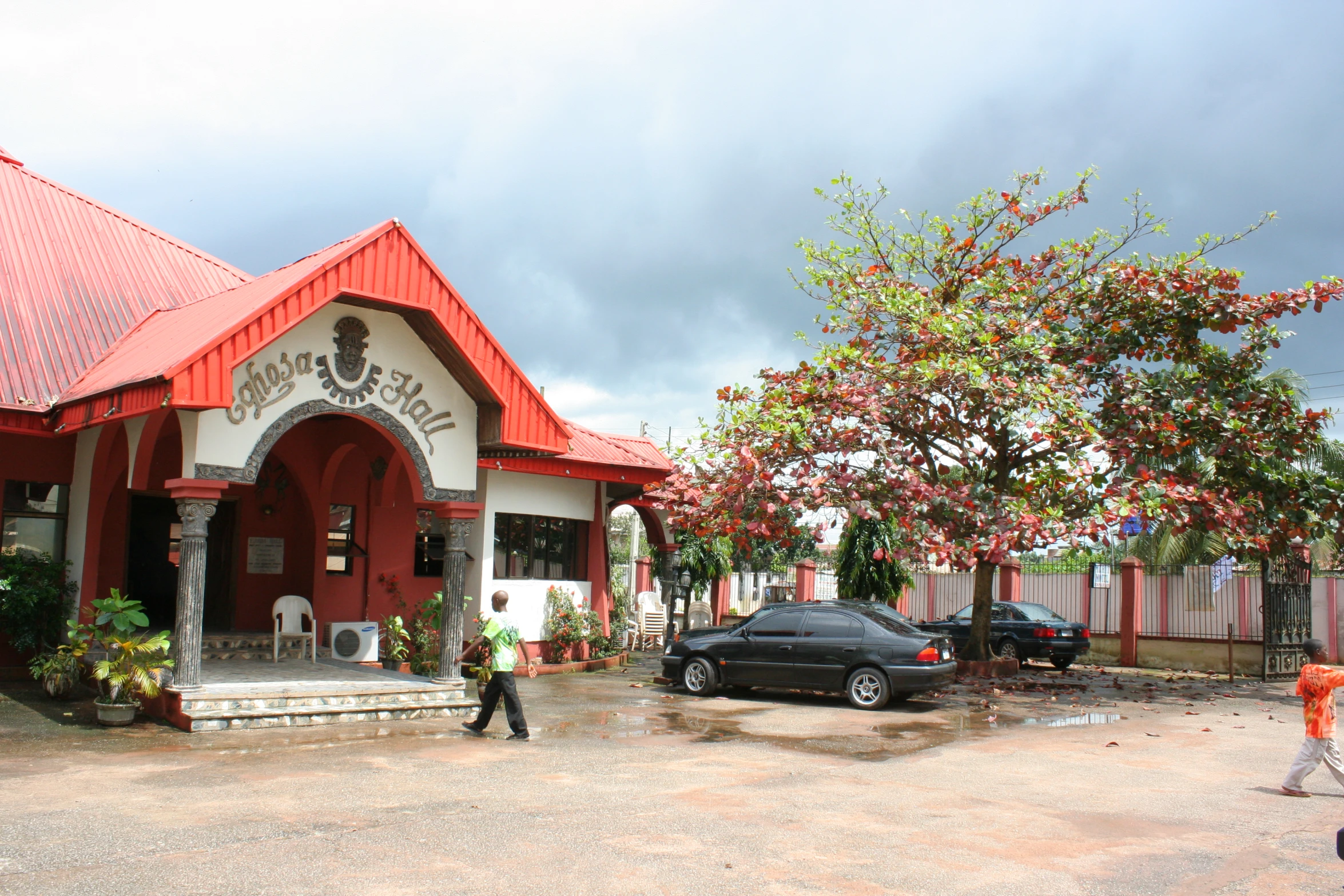 people walking by the front of a red and white church