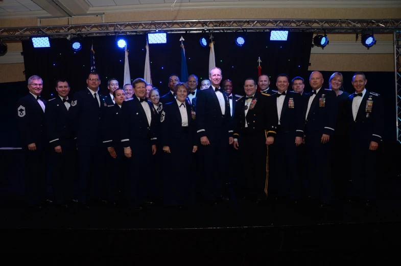 military members on stage posing for a group po