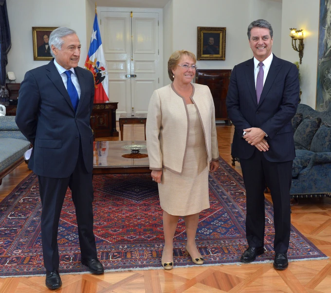 two men and one woman smile as they stand in the room together