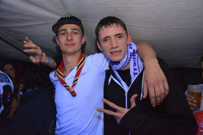 two men who are holding up medals on a pole