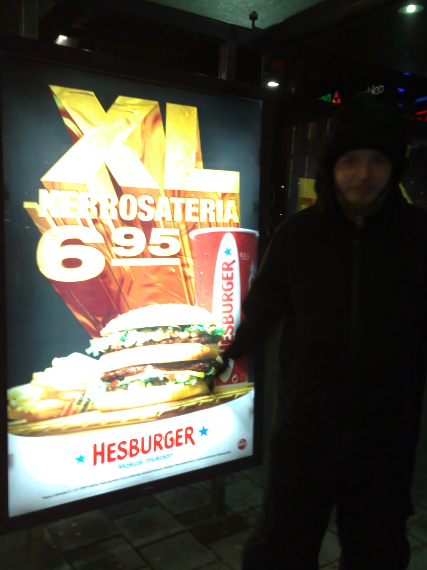 a man standing next to a billboard in a parking lot