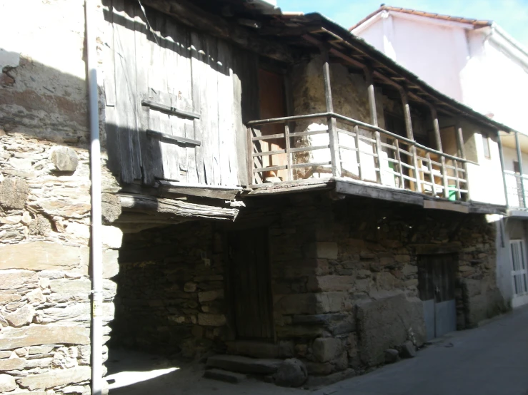 an old stone building has a porch with bars on it