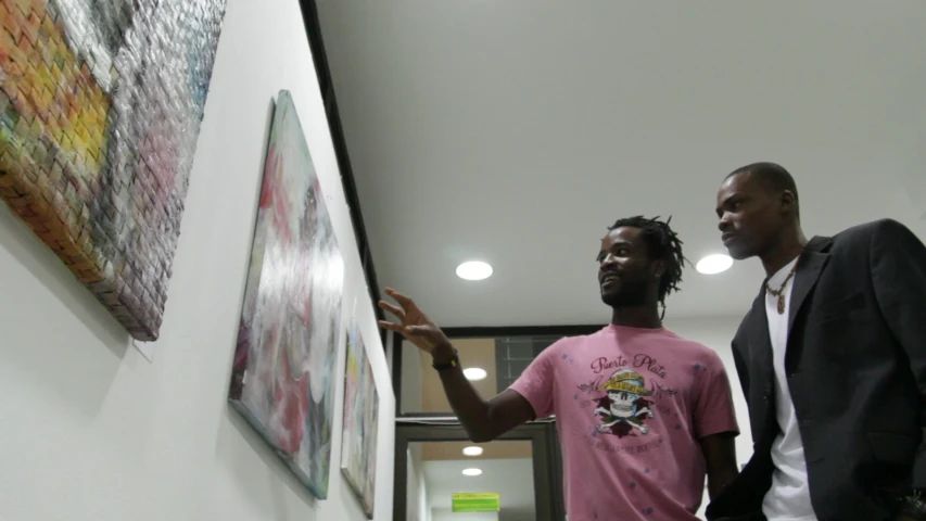 two people standing near a wall looking up