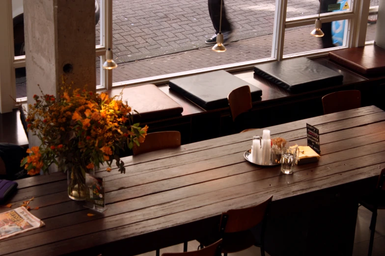 a restaurant dining area with tables, chairs and an open door