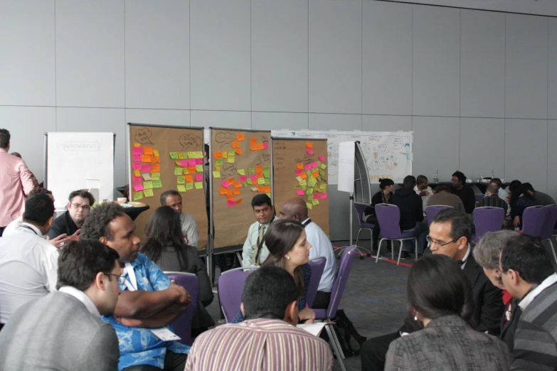 people in a crowded meeting room looking at a poster with words on it