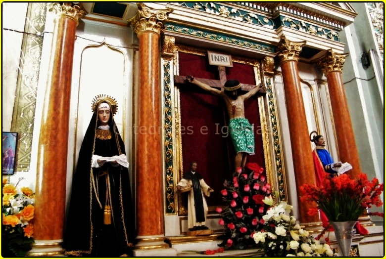 a statue of jesus on a wooden cross in front of a church