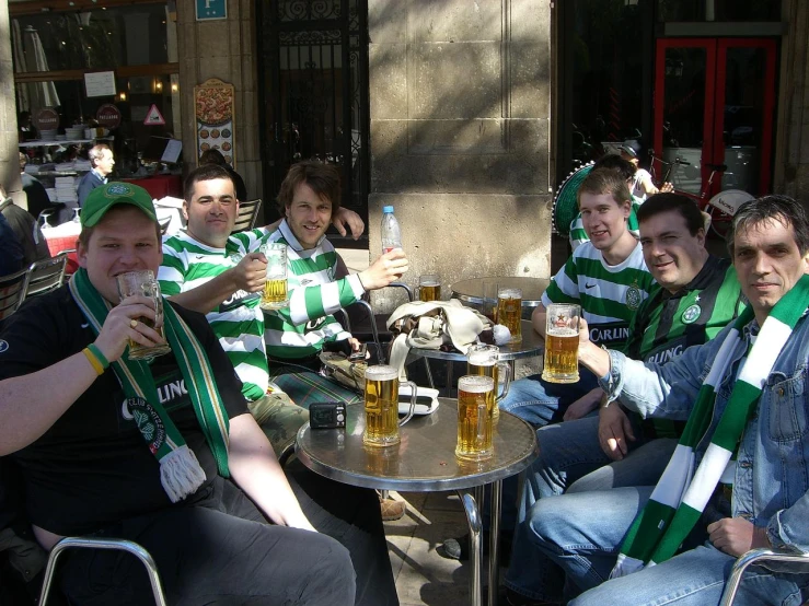 several people pose for a po while drinking beer