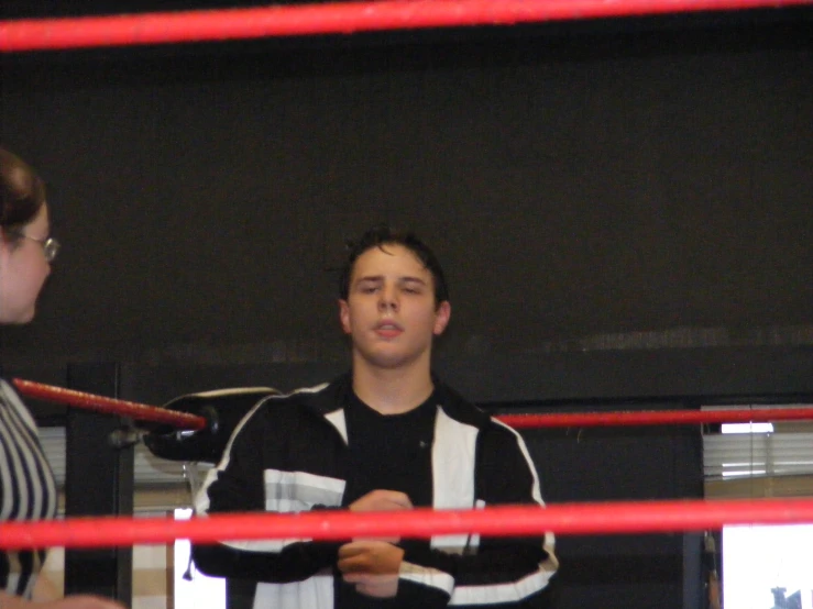 a man is speaking to another wrestler in a cage