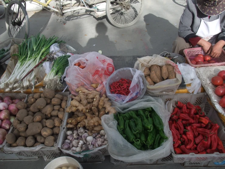 people are sitting at a food stand with fresh produce