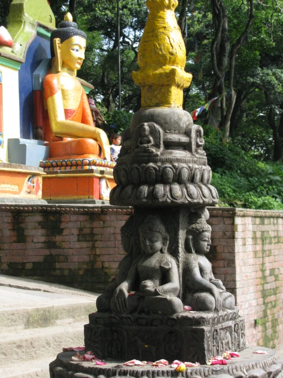 a statue and a sitting buddha in the background