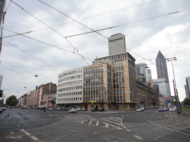 an empty intersection on a city street with a large building