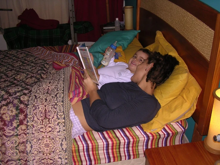 a woman laying in bed with an open book