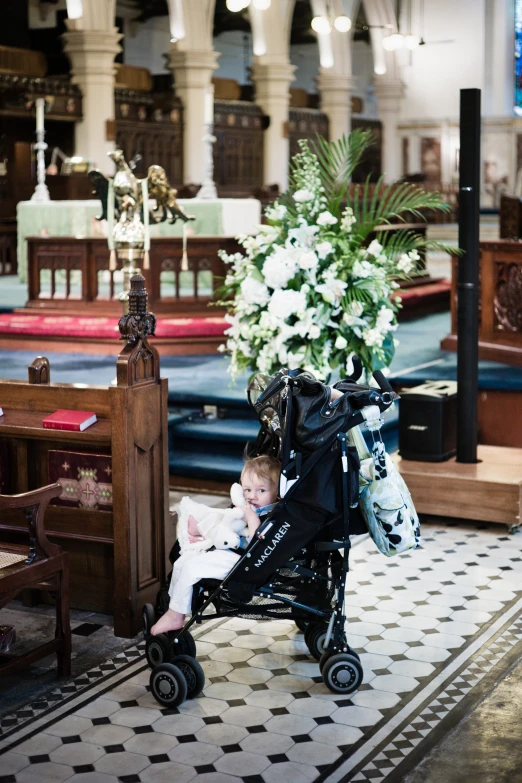 a  riding in a stroller with flowers