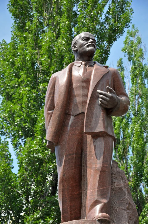 a statue of a man standing in front of trees