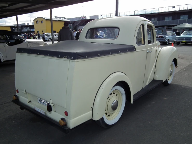 an old fashioned white car in a parking lot