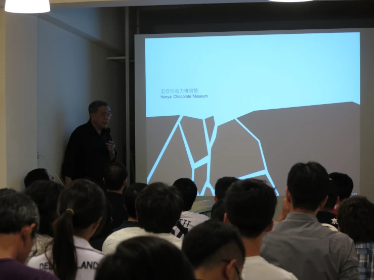 man giving a lecture to his class in front of a large crowd