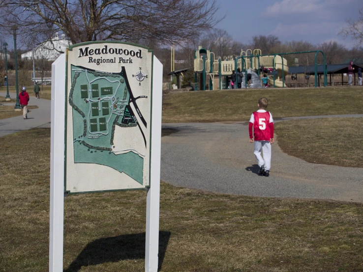 a park sign in front of a 's playground