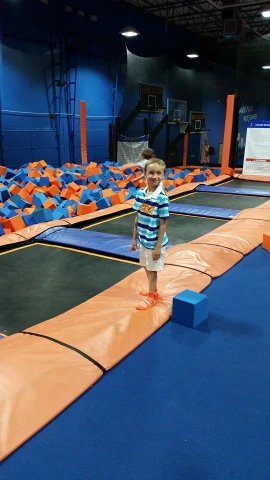 a boy standing on top of a trampoline