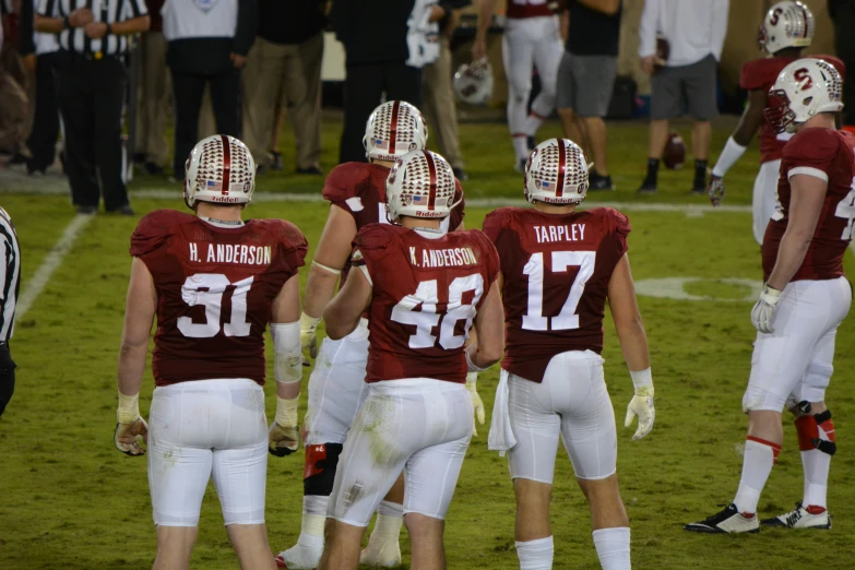 a group of football players standing on top of a field