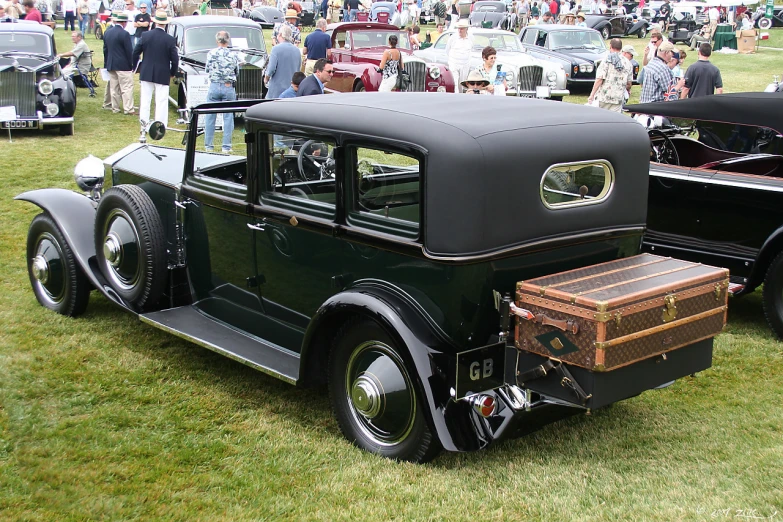 an old - fashioned truck and black car on display at a car show