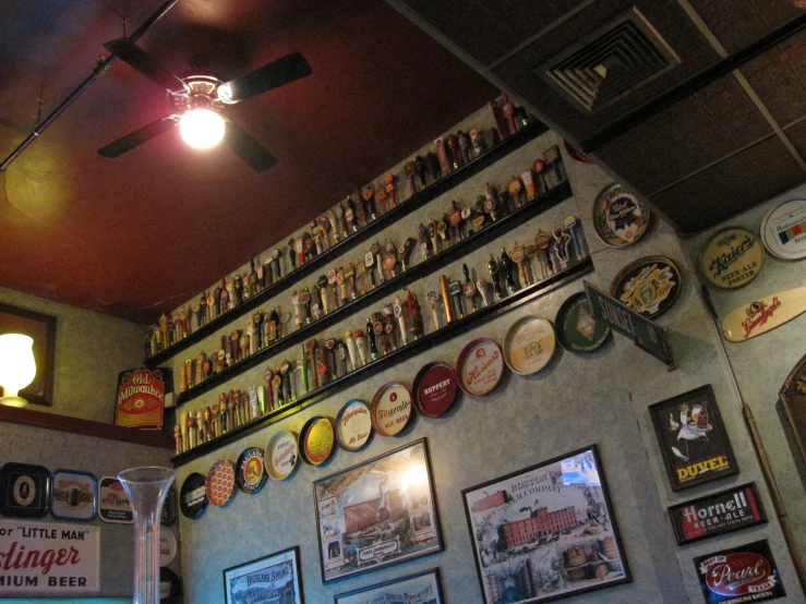 a bar has a lot of beer plates and beer bottles on the wall