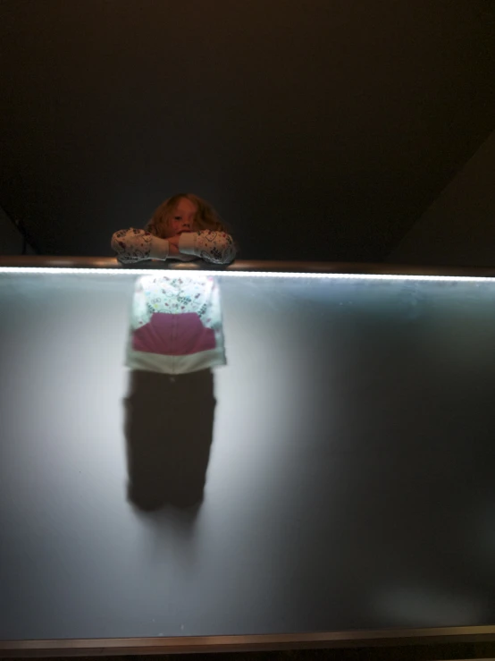 a person standing in the dark on top of a glass