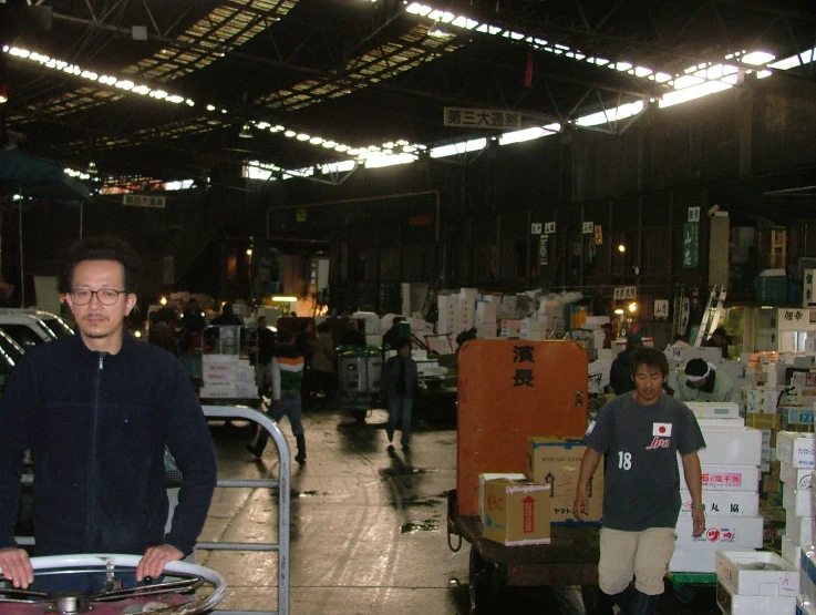 a man standing in a warehouse with lots of supplies