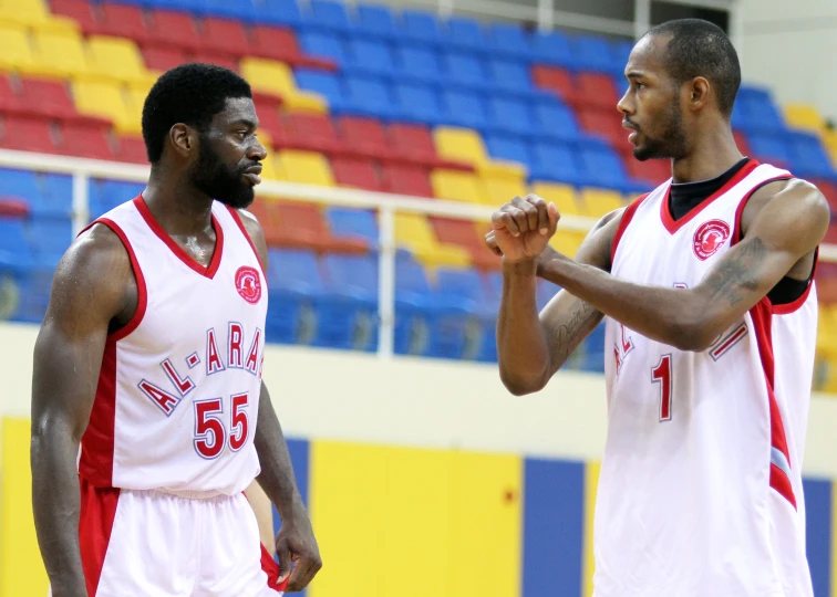 two men in basketball uniforms on the court