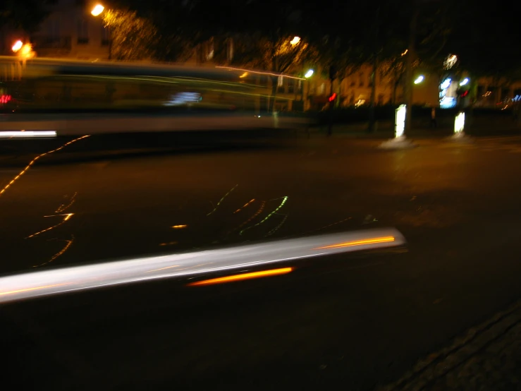blurry image of a street at night with lights on