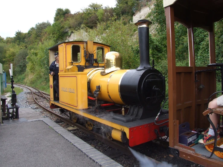 a small yellow train engine at a train station