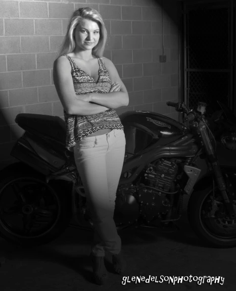 woman standing next to motorcycle and posing in black and white po