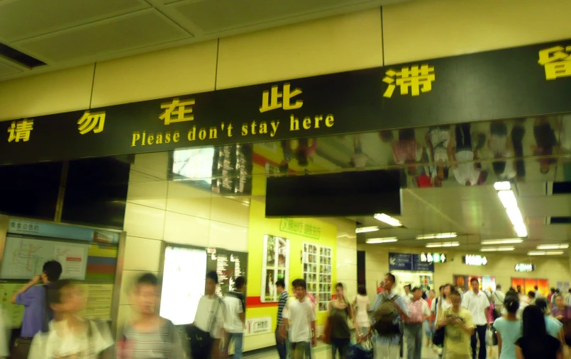 a large group of people walking under an asian sign