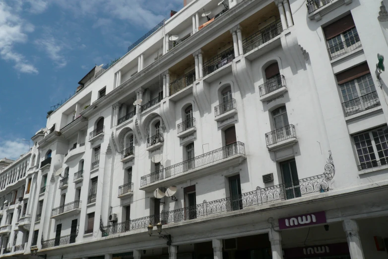 some very tall white buildings with balconies