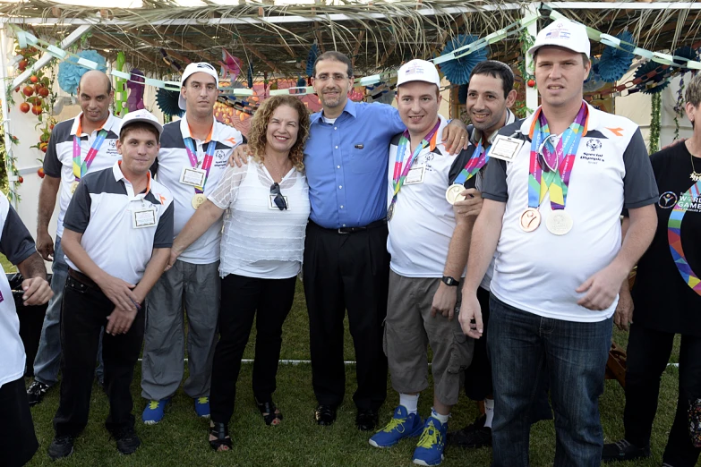 a group of people standing together holding medals