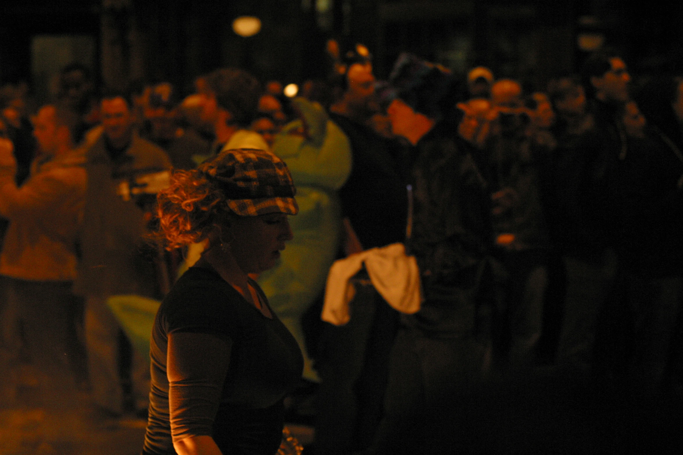 woman in head band walking past a large crowd