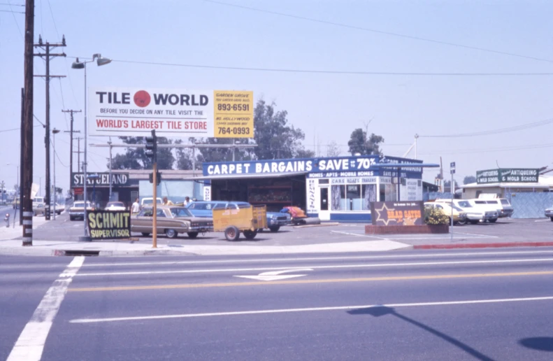 many cars and buses parked in front of a building