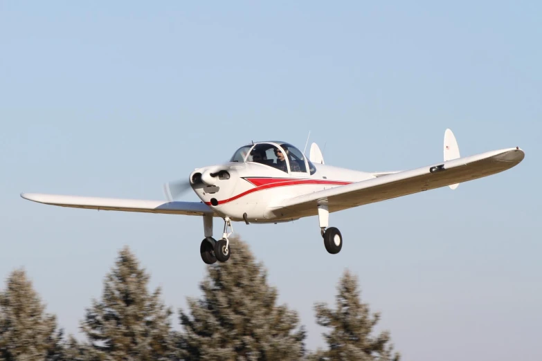 an airplane is flying over trees in the air