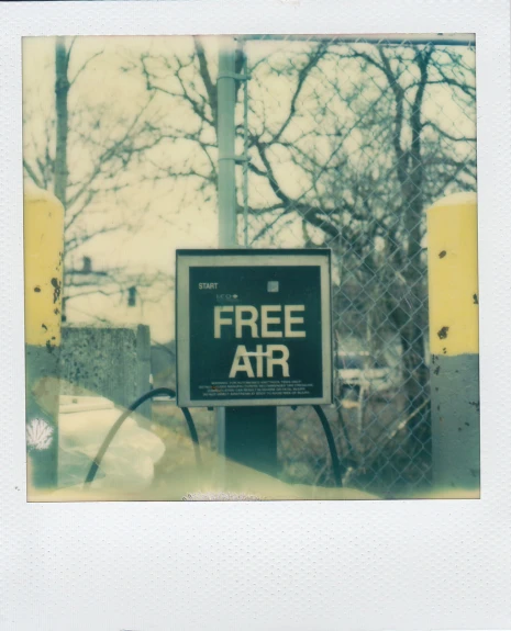 a free air sign by a chain link fence