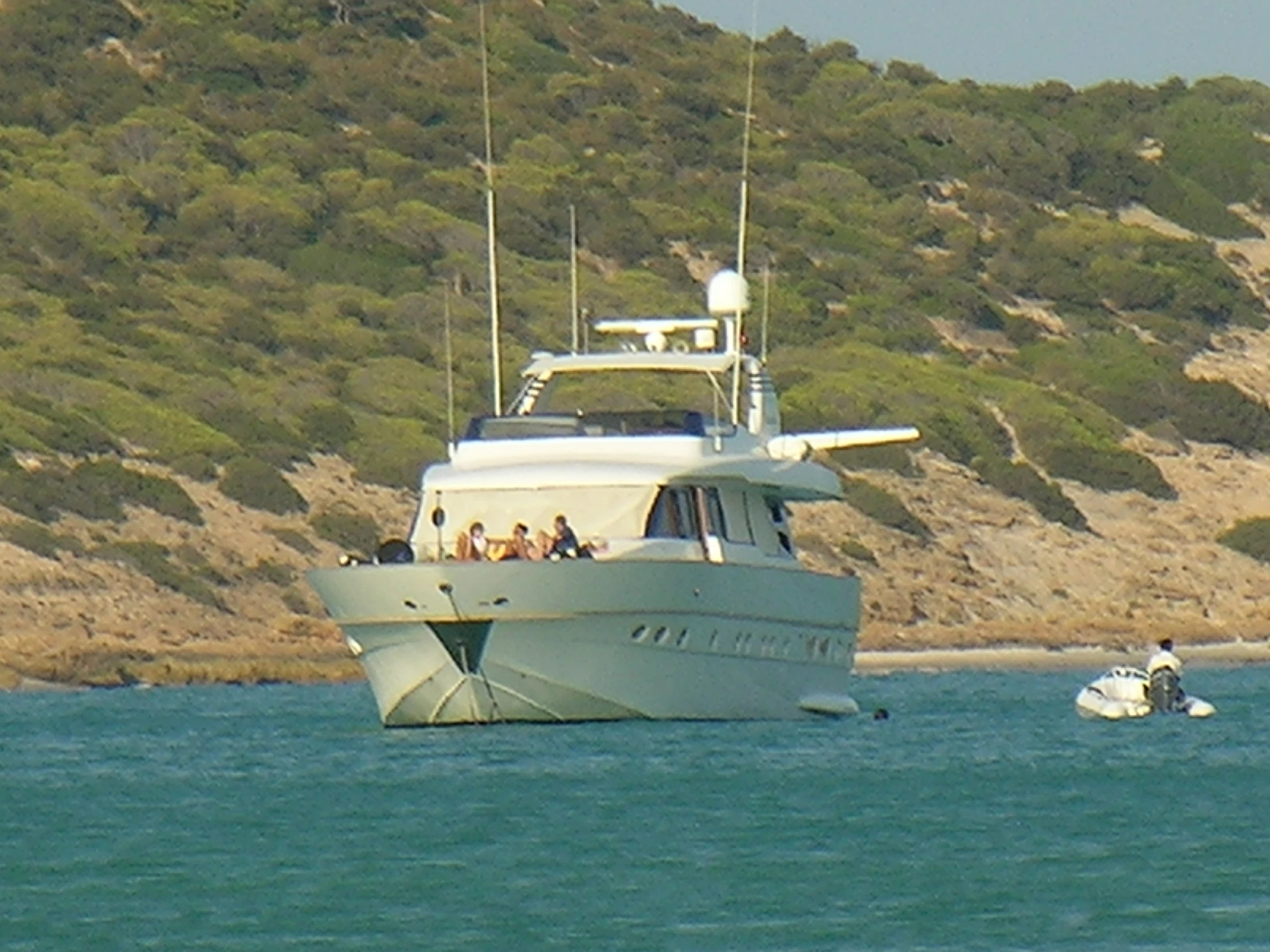 a boat sails toward some mountains and a small beach