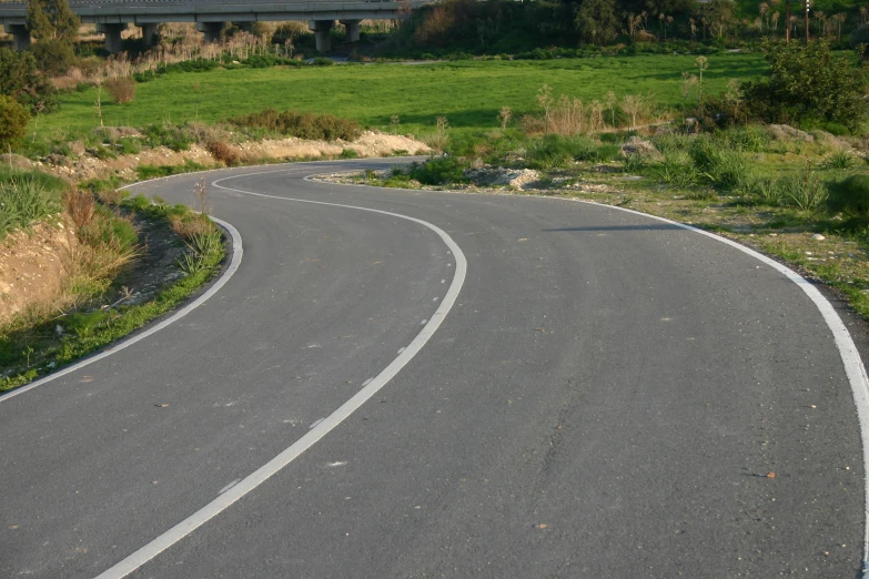 a curved road in the middle of a rural area