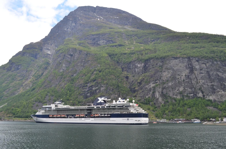 the cruise ship is near the mountains and the water