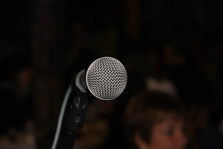 a microphone with blurry background of people sitting at tables