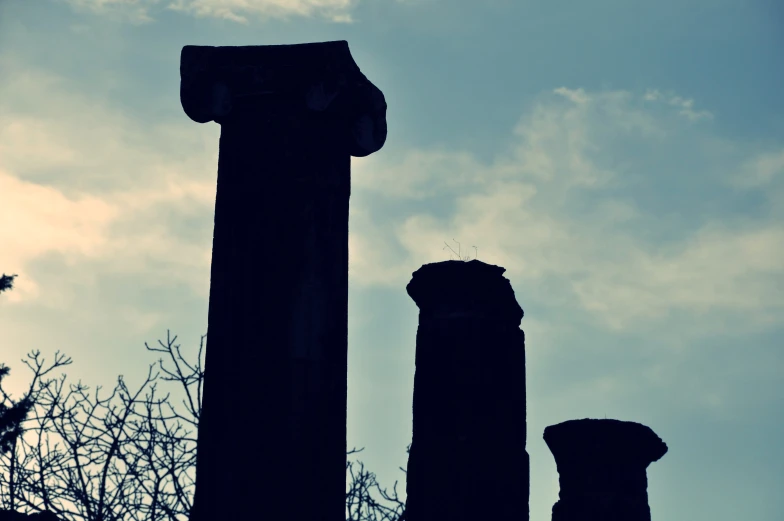 several very tall pillars against a blue sky