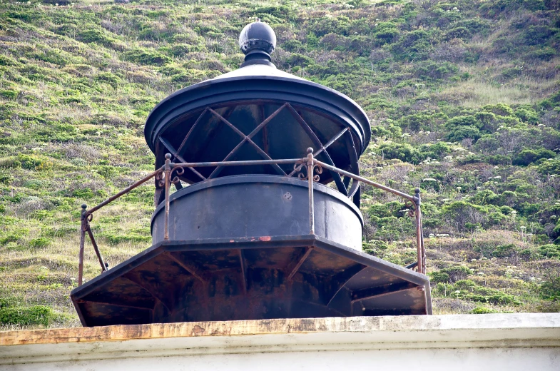 an old black lighthouse sits on the side of a mountain