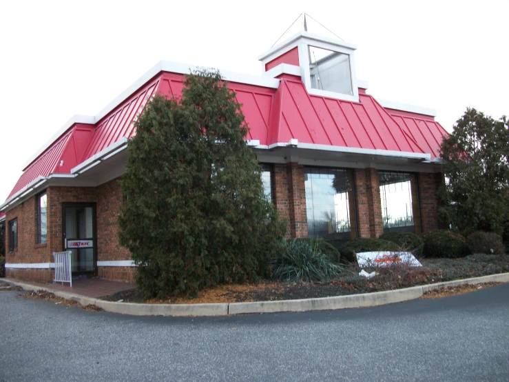 there is a small red building next to the road