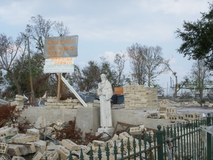 a sign in a yard near a pile of stone